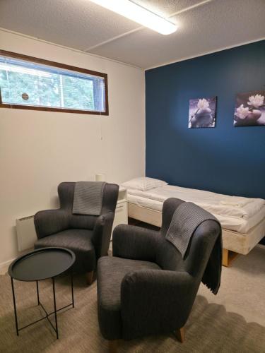 a room with a bed and two chairs and a table at Kotoisa 2 in Seinäjoki
