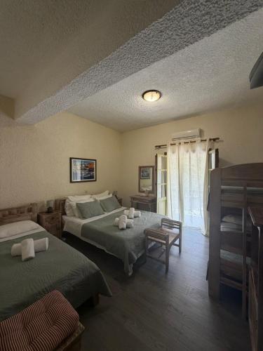a hotel room with two beds and a window at Akrotiri B&B in Porto Kagio