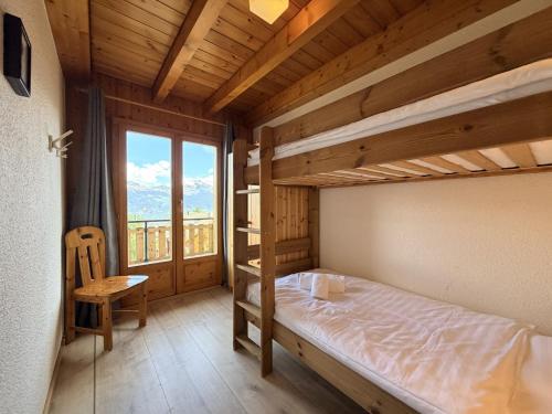a bedroom with two bunk beds and a chair at Mont Bijou MOUNTAIN & QUIET chalet 10 pers by Alpvision Résidences in Veysonnaz