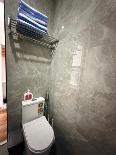 a bathroom with a toilet and some towels at Manatad Transient Family -2 in Surigao