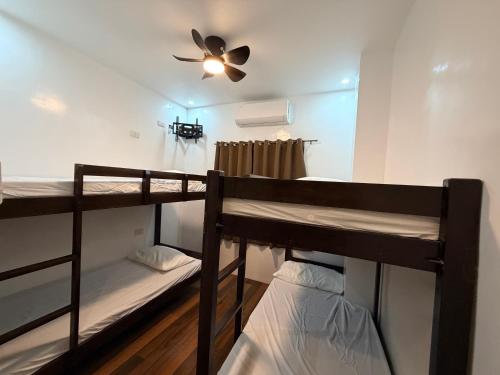 two bunk beds in a room with a ceiling fan at Manatad Transient Family -2 in Surigao