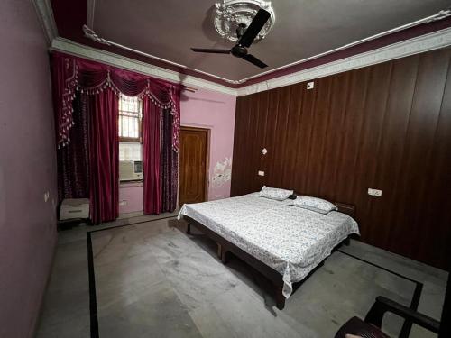 a bedroom with a bed and a ceiling fan at Home stays subash nagar in Jammu