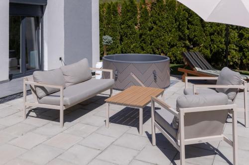 a patio with two chairs and a table and a tub at Villa Alba Rekavice Krupa na Vrbasu in Banja Luka