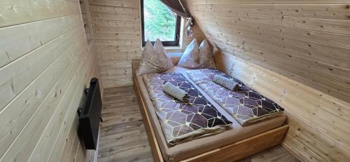 a bedroom with a bed in a wooden wall at Farma pod Skalkou in Heľpa