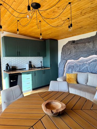 a kitchen and living room with a table and a couch at Pitoresc Cabin in Tranisu