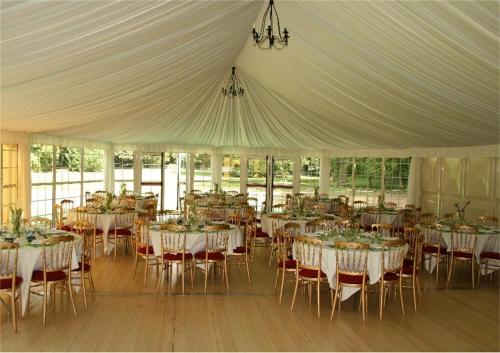 une tente blanche avec des tables et des chaises. dans l'établissement Le Château de Philiomel, à Lillers