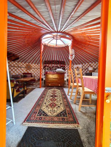 a yurt with a table and chairs and a rug at Duva jurta in Bistrica