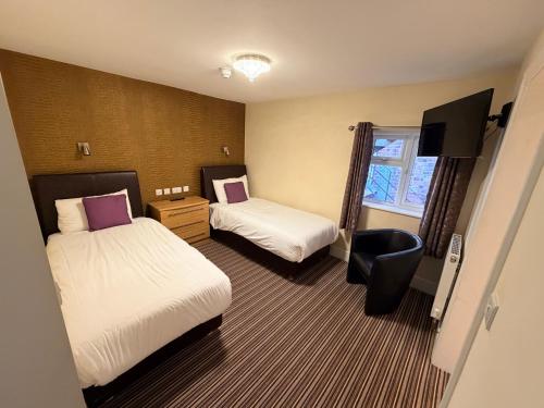 a hotel room with two beds and a television at Imperial Lodge in Great Yarmouth