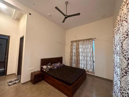 a bedroom with a bed and a ceiling fan at shreeraj farms in Kolshet
