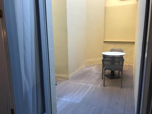 a small table and a chair in a room at Hôtel & Appartements Monsigny in Nice
