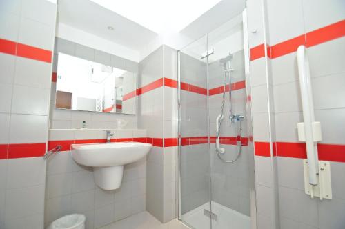 a white bathroom with a sink and a shower at Torino 1854 Affittacamere in Turin
