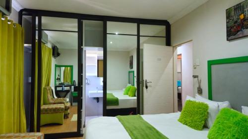 a bedroom with a bed with green pillows at Zungu b&b in KwaDukuza