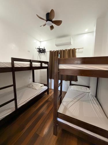 a room with three bunk beds and a ceiling fan at Manatad Transient Family 3 in Surigao