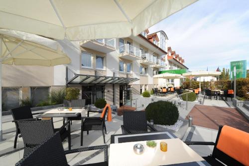 an outdoor patio with tables and chairs and a building at Hotel Markkleeberger Hof in Markkleeberg
