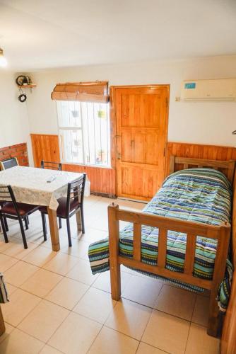 a bedroom with a bed and a table and chairs at La Casa de Doña Adela in Eugenio Bustos