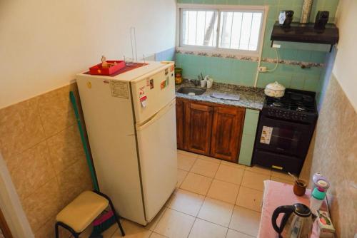 a small kitchen with a refrigerator and a stove at La Casa de Doña Adela in Eugenio Bustos