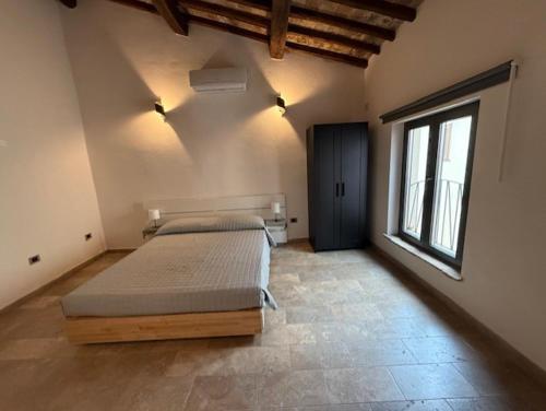 a bedroom with a bed and a large window at Alla botte degli Orsini in Attigliano