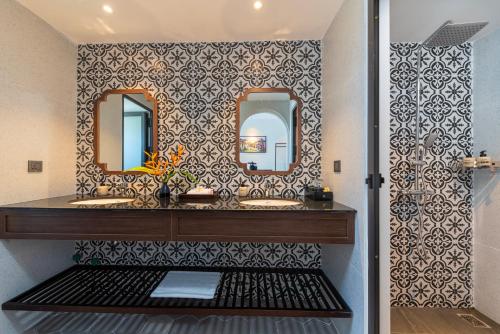 a bathroom with two sinks and a mirror at BACKHOME BOUTIQUE Old Town Hoi An in Hoi An