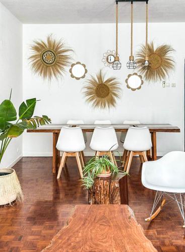 a dining room with a wooden table and white chairs at Di Vine in Maputo