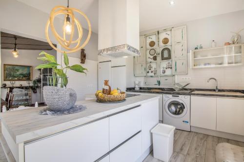 a kitchen with white cabinets and a bowl of fruit on a counter at El Encanto in Villarrasa