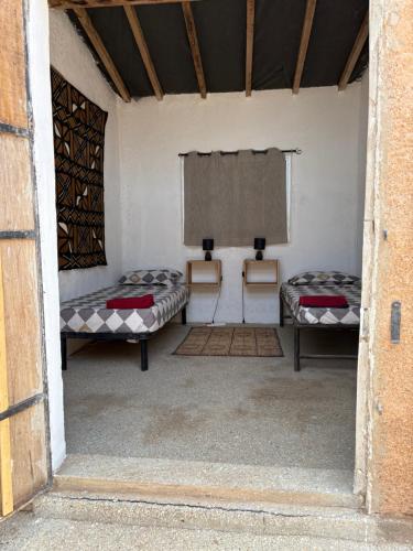 a room with two beds in it with a window at Nougouranch in Rufisque