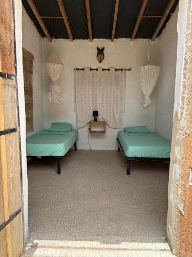 a room with two beds and a window at Nougouranch in Rufisque