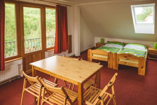 a bedroom with a bed and a table and chairs at Penzion U Černého Potoka in Nová Lhota