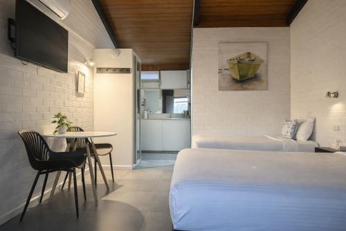 a hotel room with two beds and a table and a table at Jetty Motel The Entrance in The Entrance