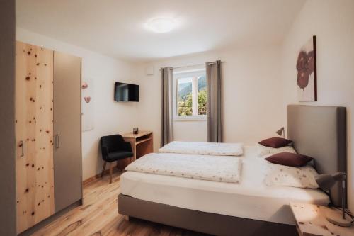 a bedroom with a large bed and a desk at Falgerhof in Vollan