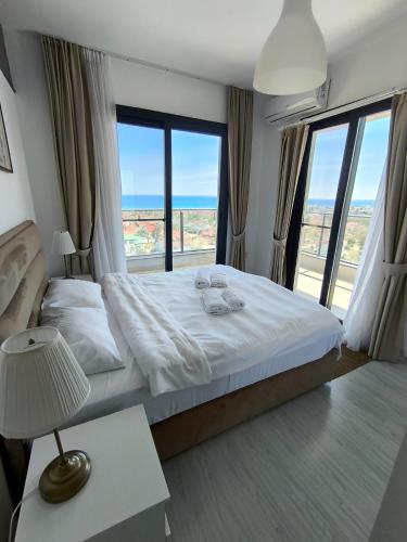 a bedroom with a bed with a view of the ocean at Caesar Blue Resort & Spa apartment I-66 in Kalecik