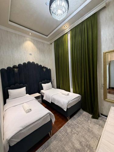 a bedroom with two beds and a large window at Global Star Hotel in Samarkand