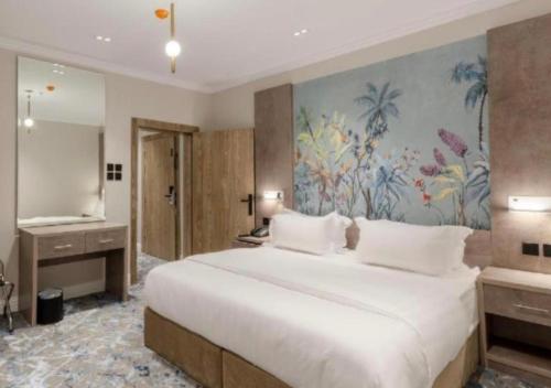 a bedroom with a large bed and a painting on the wall at فندق فاتوران in Medina