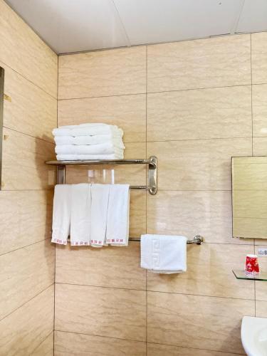 a bathroom with white towels hanging on a wall at 巨缿民宿巨象民宿 in Sanyi