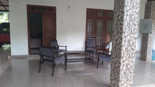a room with chairs and a wooden table in a house at The banglow homestay in Anuradhapura
