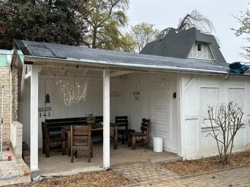 a white pavilion with a table and chairs on a patio at Strandvilla Rheingold in Göhren