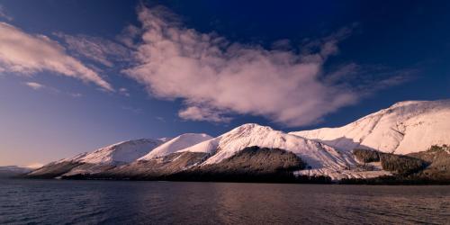 a group of snow covered mountains next to a body of water at Corriegour Lodge Hotel in Spean Bridge