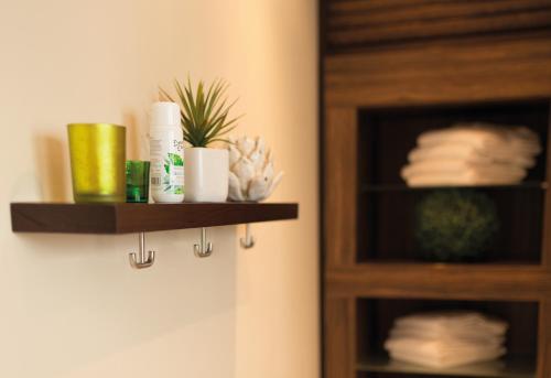 a bathroom with a shelf with toiletries and towels at Hotel Markkleeberger Hof in Markkleeberg