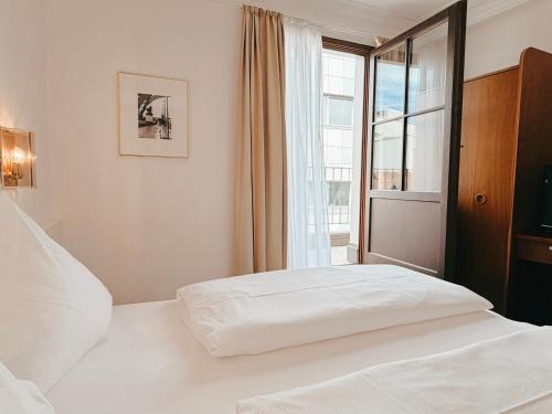 un letto bianco in una stanza con una finestra di Hotel Boulevard a Costanza