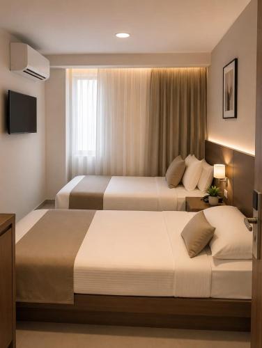 a hotel room with two beds and a television at new Villa117 in Cairo