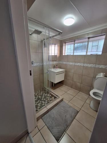 a bathroom with a shower and a toilet at Rams Blissful Guest House in Rustenburg