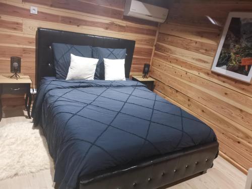 a bedroom with a large bed with wooden walls at Le Chalet Atypique in Saint-Pierre