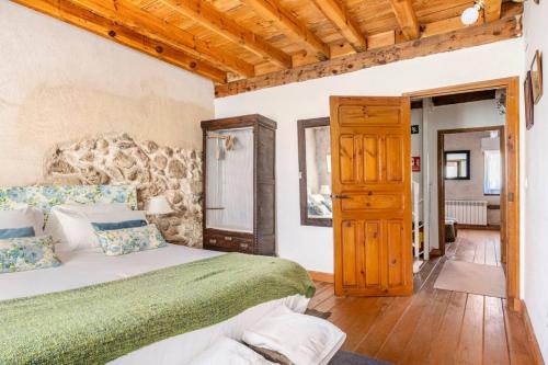 a bedroom with a bed and a wooden ceiling at Casa Valle del Lozoya in Rascafría