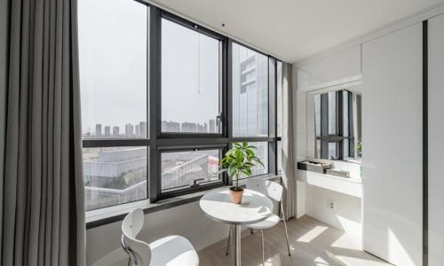 a white table and chairs in a room with windows at Incheon Songdo Stay31 in Incheon