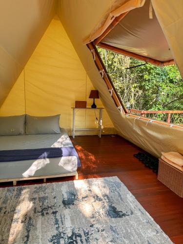 a bedroom with a bed in a tent at Bandu Buana Glamping in Kuala Pilah