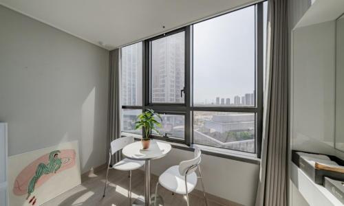 a room with a table and chairs and a large window at Incheon Songdo Stay31 in Incheon