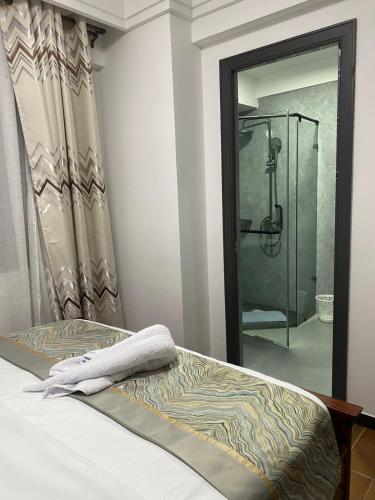 a bedroom with a shower and a bed and a mirror at Kindaruma Homes Apartments in Nairobi