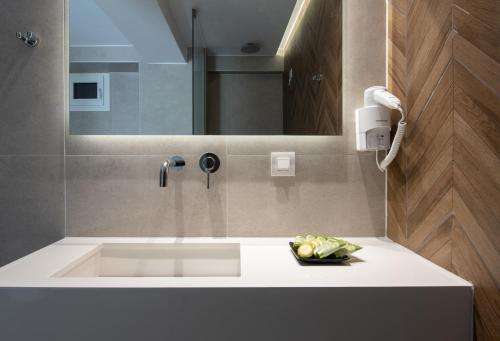 a bathroom with a sink and a mirror at Hanioti Central Hotel in Hanioti