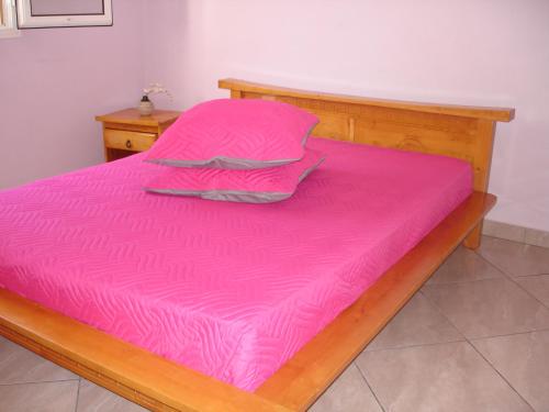a bed with a pink sheets and pillows on it at villa les Grenadines in Entre-Deux