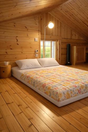 a bedroom with a large bed in a wooden wall at HIMOS Petäjäkuja 3 in Himos
