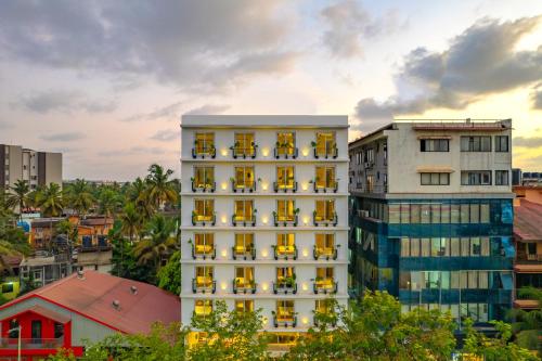 a tall white building with yellow windows at Minimalist Panjim in Panaji
